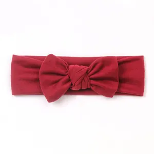 Close-up of the textured burgundy knit fabric and knotted bow detail on a baby headband