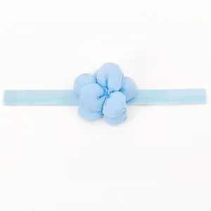 Dettaglio di una fascia per neonati celeste con decorazione floreale in tessuto 3D