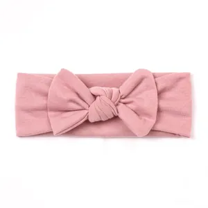 Detail of dusty pink knitted baby headband with a soft textured bow for infants