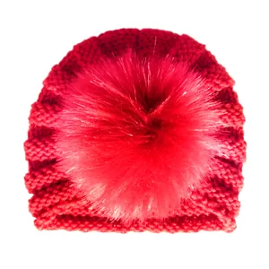 Dettaglio della trama in maglia di un berretto rosso per neonati con grande pompon