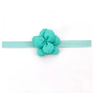 Dettaglio della fascia con fiore in tessuto verde menta con nastro elastico su cartoncino