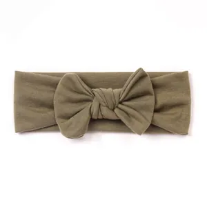 Detailed view of olive green ribbed knit baby headband with 3D decorative bow accent