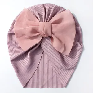 Détail d'un bonnet turban pour bébé en coton côtelé lilas avec un grand nœud en mousseline