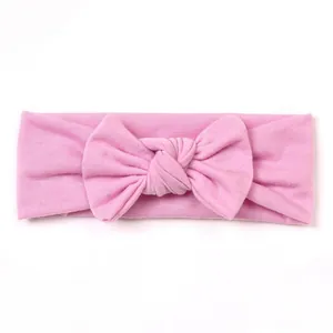 Detailed view of pink knitted baby headband featuring a soft cotton bow design