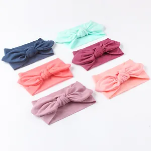 Set of six soft nylon baby headbands with large bows in mint, burgundy, and pink tones