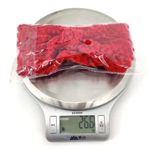 Detail showing red knitted baby headband on a scale, weighing approximately 26.6 grams