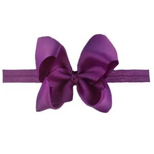Detailed macro shot of dark purple ribbed grosgrain ribbon bow on soft elastic headband