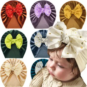 Detail of velvet baby turban hats with golden polka dot bows in multiple colors