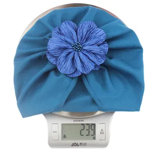 Dettaglio di un cappello a turbante blu con fiore decorativo che pesa 23,9 g