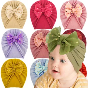 Detailed view of baby turban hats with large mesh polka dot bows in assorted soft colors