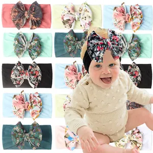 Close-up of floral print baby headbands with large bows and soft elastic fabric