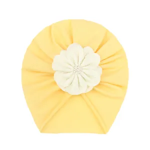 Turbante neonato giallo morbido con un grande fiore bianco in tessuto e decorazione
