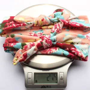 Detail shot showing two floral rabbit ear headbands on a scale weighing 27.4g