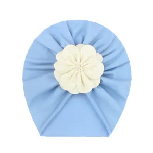 Turbante neonata azzurro con decorazione floreale in tessuto morbido e design plissettato