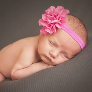 Gros plan détaillé d'un bandeau pour bébé rose avec une grande fleur en tissu doux