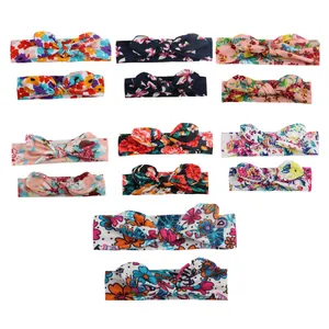 Flat lay of 12 assorted floral print baby headbands with bunny ear knot bows