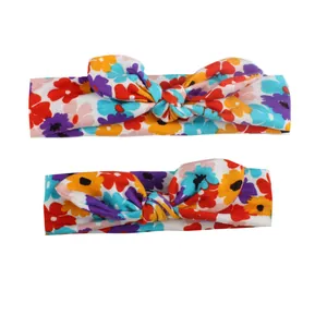 Close-up of dual-size floral knotted rabbit ear headbands with soft elastic fabric