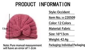 Pink knit baby turban hat with bow detailing showing dimensions 16x13cm and soft texture