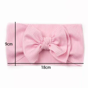 Pink ribbed fabric baby headband with bow detail showing size dimensions 18x9cm