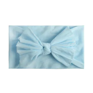 Detail van een zachte lichtblauwe nylon baby hoofdband met een grote handgemaakte strik
