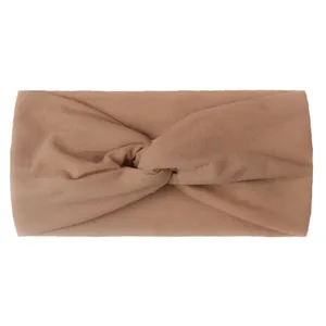 Detail of camel colored nylon hair band featuring a cross-knot knitted texture for girls