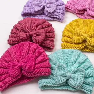 Detail shot of newborn knit beanies featuring large bows in multiple vibrant colors