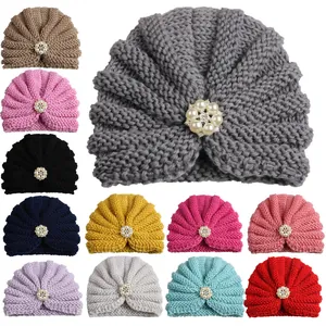Detailed view of 12-color variety baby turban hats with pearl and rhinestone floral center