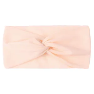 Detail of soft pale orange nylon twisted knot headband for baby girls with fabric texture