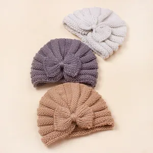 Detailed knit texture of warm baby turban hats with large bows in three colors