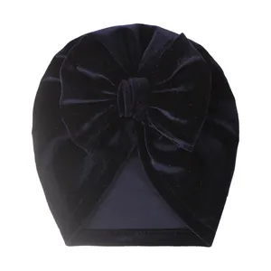 Détail du bonnet turban pour bébé en velours bleu foncé avec un grand nœud décoratif