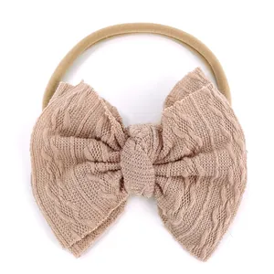 Bandeau bébé en nylon souple avec un grand nœud en maille gaufrée de couleur rose poudré