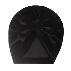 Détail du turban pour bébé en velours noir avec un grand nœud papillon texturé