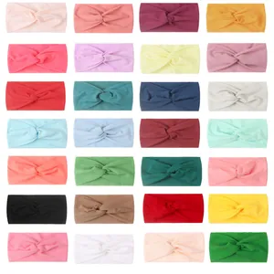 Set of 28 solid color nylon baby headbands featuring soft twisted knots in a grid layout