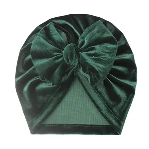 Détail du bonnet turban pour bébé en velours vert foncé avec un grand nœud souple