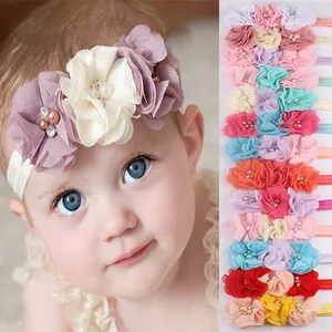 Detail of baby flower headbands with three large chiffon blossoms and pearl accents