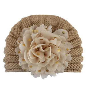 Nahaufnahme Baby-Strickmütze mit großer Goldpunkt-Chiffonblume als Detail