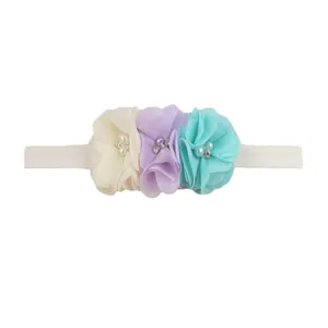 Detailed view of chiffon flowers with pearls and rhinestones on baby elastic headband