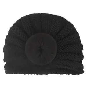 Dettaglio del turbante nero per neonati con nodo a ciambella a spirale e trama in maglia