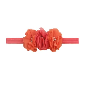 Detail of three chiffon flowers with pearls and rhinestones on an elastic baby headband