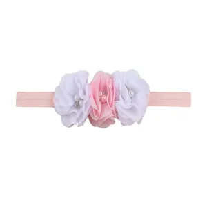 Detail of baby headband with three chiffon flowers, faux pearls and sparkly rhinestones
