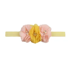 Detailed view of chiffon flowers with pearls and rhinestones on baby elastic headband