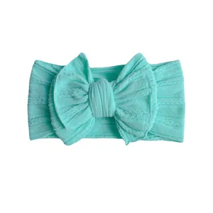 Mint green knitted nylon bow headband for infants with a stylish twisted texture design