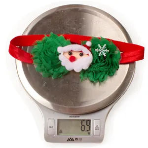 Detailed view of lightweight Christmas baby headband with Santa motif weighing 6.9g on scale