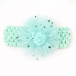 Gros plan sur un bandeau bébé vert menthe avec sequins étoiles sur pétales en maille