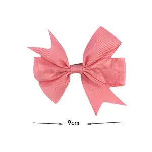 Detail of pink grosgrain ribbon bow clip with 9cm width measurement and ribbed texture