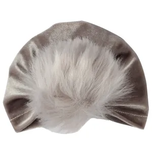 Dettaglio cappello turban in velluto per neonati con pompon in ecopelliccia rosa