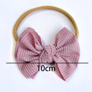 Baby nylon headband featuring a 10cm dusty pink ribbed fabric bow on a nude elastic band