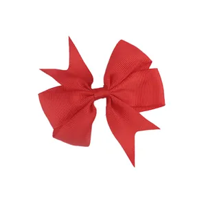 Detail of red grosgrain ribbon hair bow with layered swallowtail and woven texture
