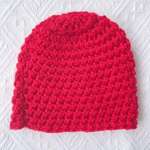 Thick red crochet knit baby winter hat with dense texture in a cozy style