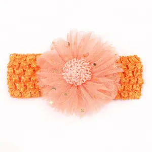 Détail du bandeau bébé avec bande crochet orange et fleur en maille avec paillettes étoiles